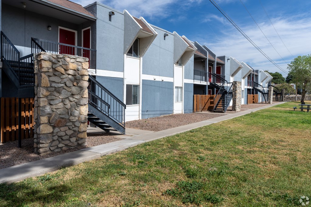 A row of modern townhouses with a stone pillar in front of the first one.