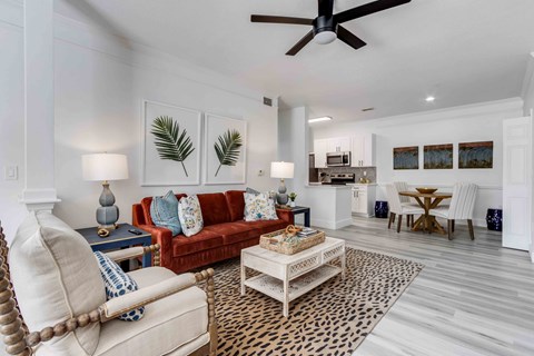 A living room with a red couch and a leopard print rug.