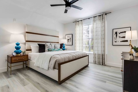 A bedroom with a large bed and a ceiling fan.