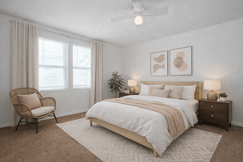 A bedroom with a large bed, a chair, and a ceiling fan.