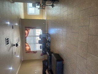 A room with a wall of windows and a wall of tiles.