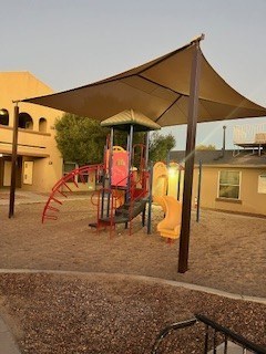 A playground with a slide and a canopy.