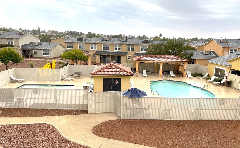 A backyard with a pool and a patio.