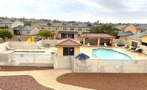 A backyard with a pool and a patio.