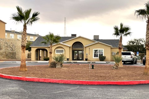 A building with a red border around it and palm trees in front.