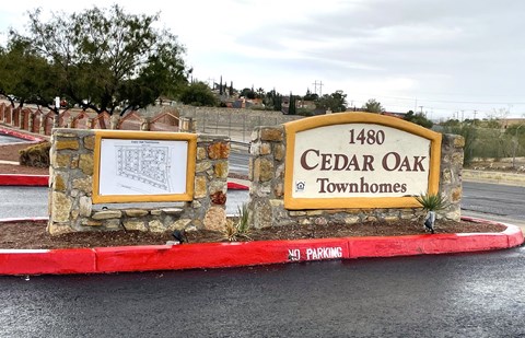 A sign for Cedar Oak Townhomes with a "No Parking" sign in front of it.