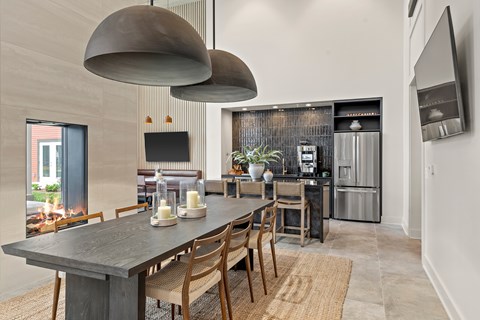 A modern dining room with a long table and chairs.