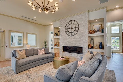 A living room with a grey couch and a fireplace.