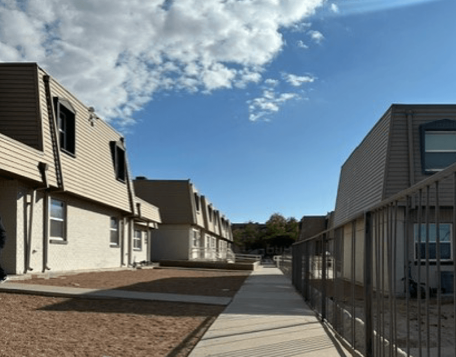 A row of modern houses with a sidewalk in front.