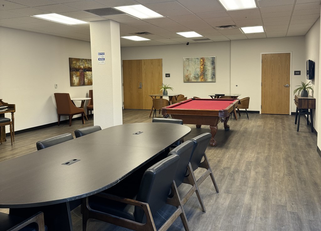 A conference room with a pool table and chairs.