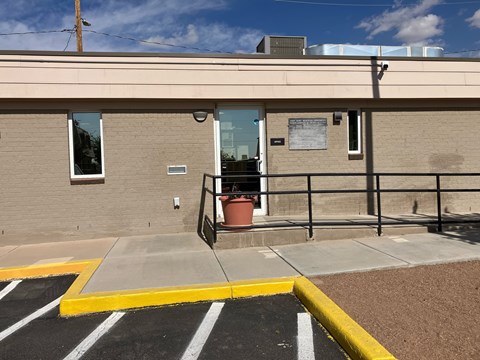 A building with a yellow and black striped parking lot in front.