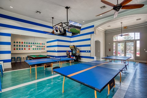 a game room with ping pong tables and a tv