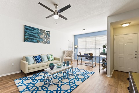 a living room with a couch and a ceiling fan