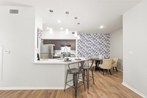 a kitchen with a bar and a dining area with stools