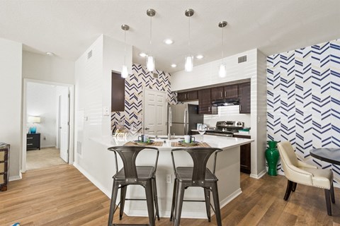 a view of a kitchen with a bar and stools