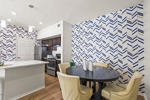 a dining room with a table and chairs and a kitchen