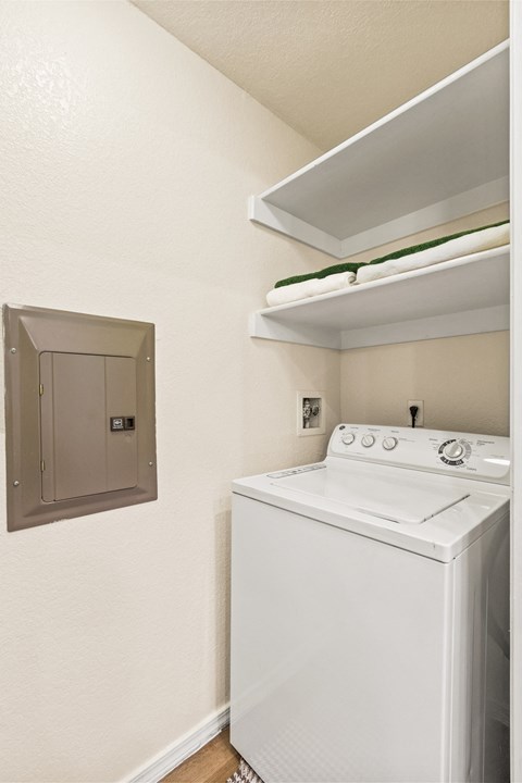 a white washer and dryer in a room with a dryer and shelf