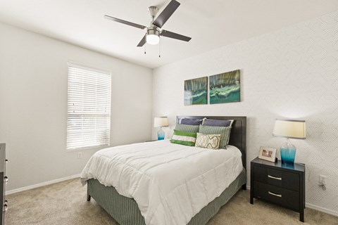 a bedroom with a bed and a ceiling fan