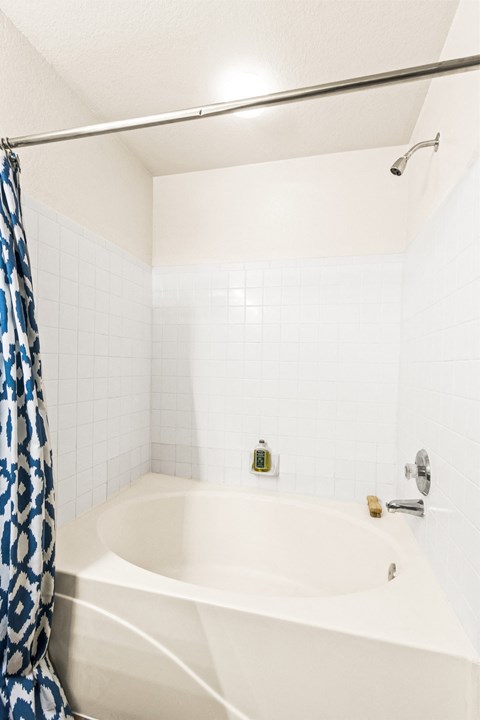 a white bathroom with a tub and a shower curtain