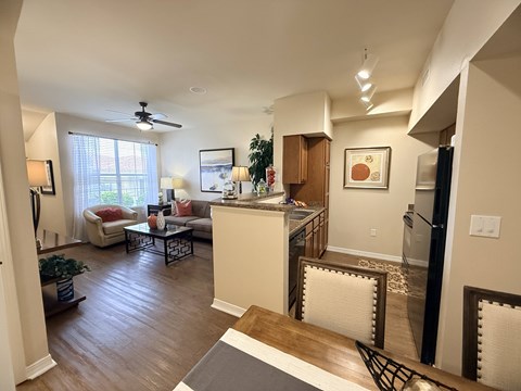A living room with a kitchen area in the background.