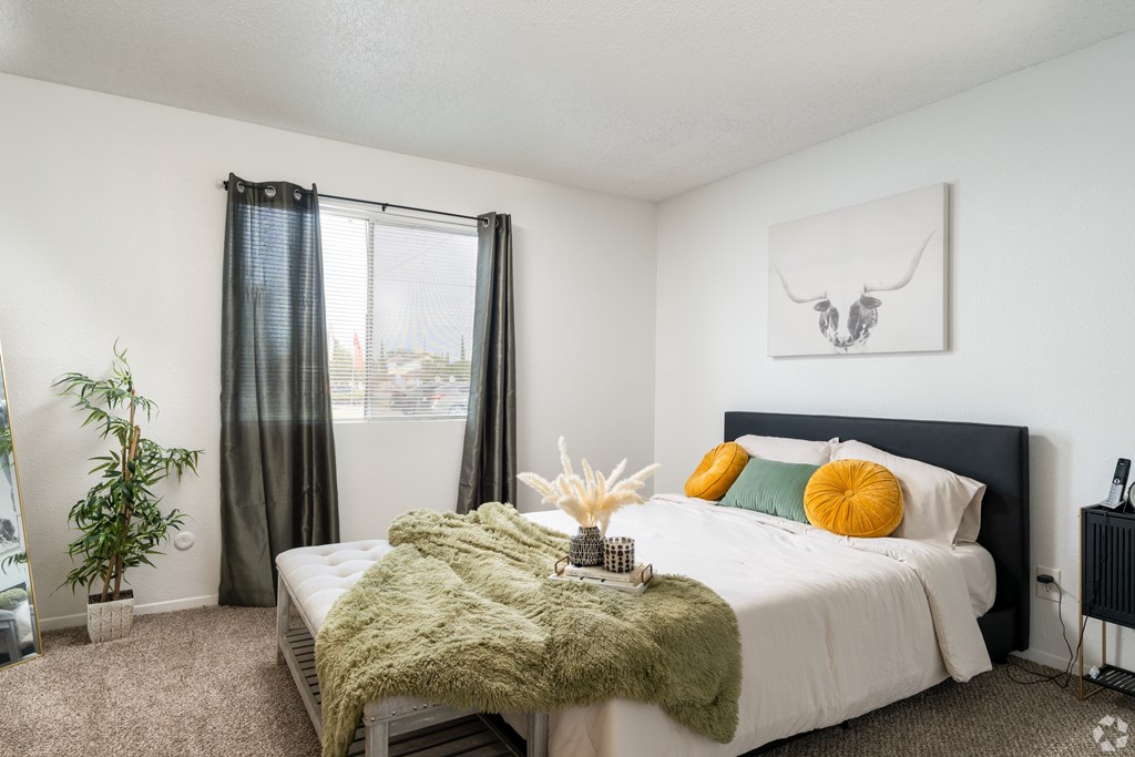 A bedroom with a large bed and a green blanket.