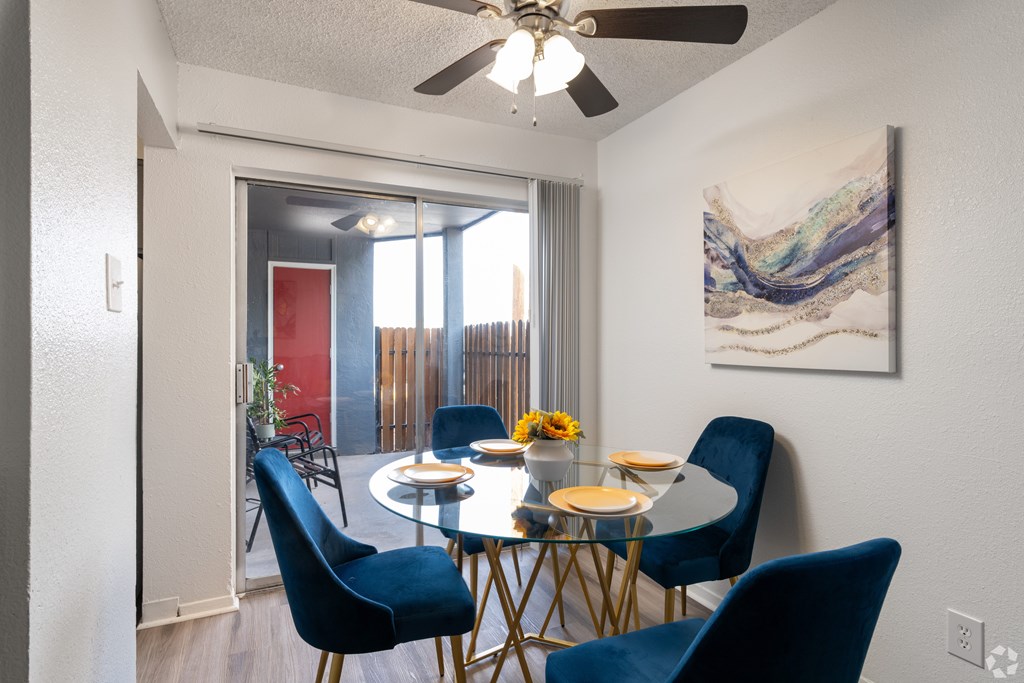 A dining room with a table set for four.