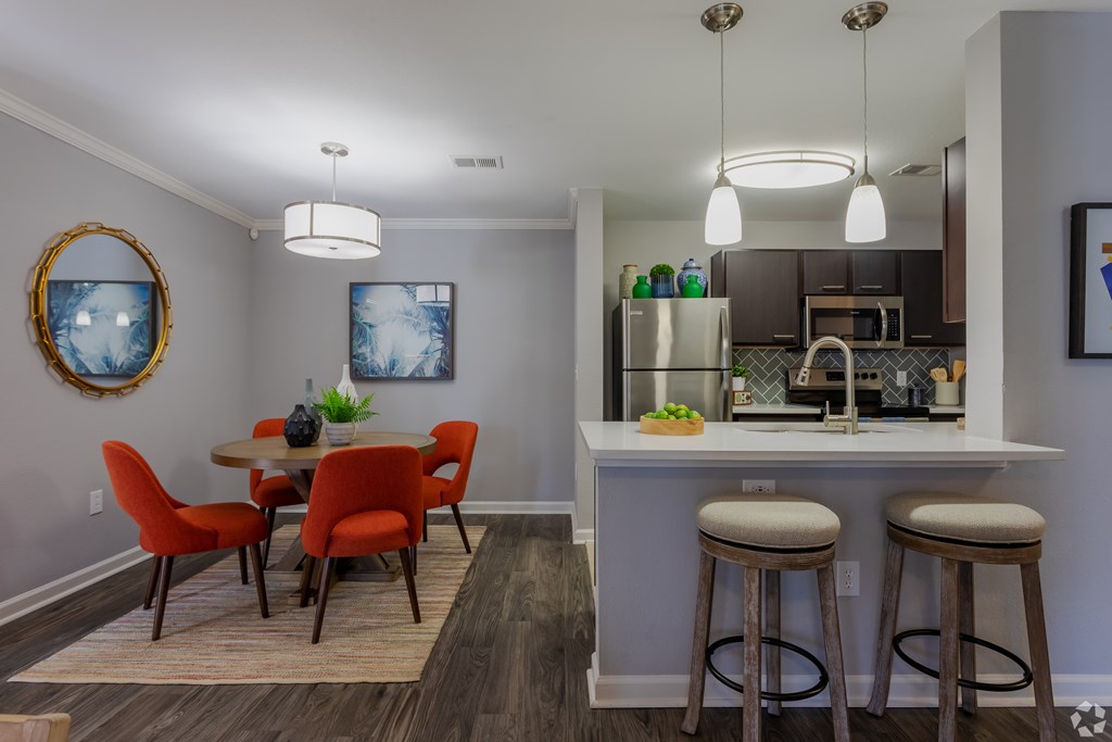 A kitchen with a dining table and chairs.