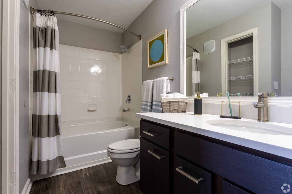 A bathroom with a toilet, sink, and shower.
