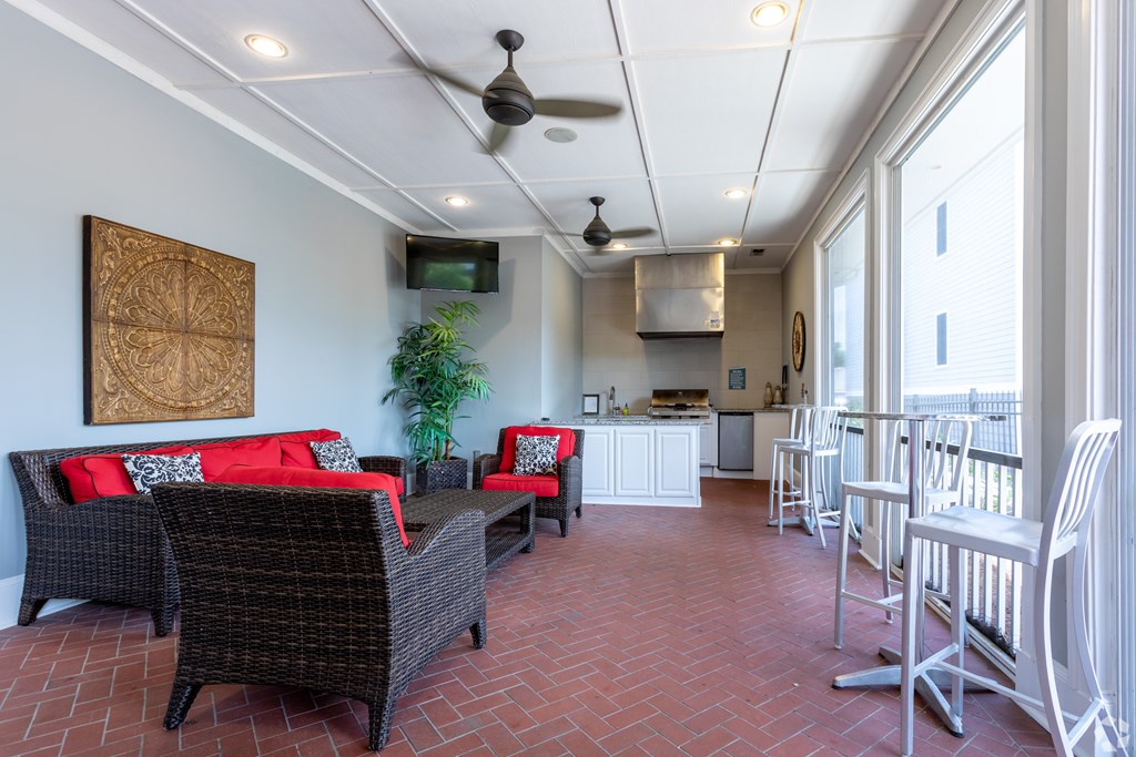 A patio with a red couch and a fan.