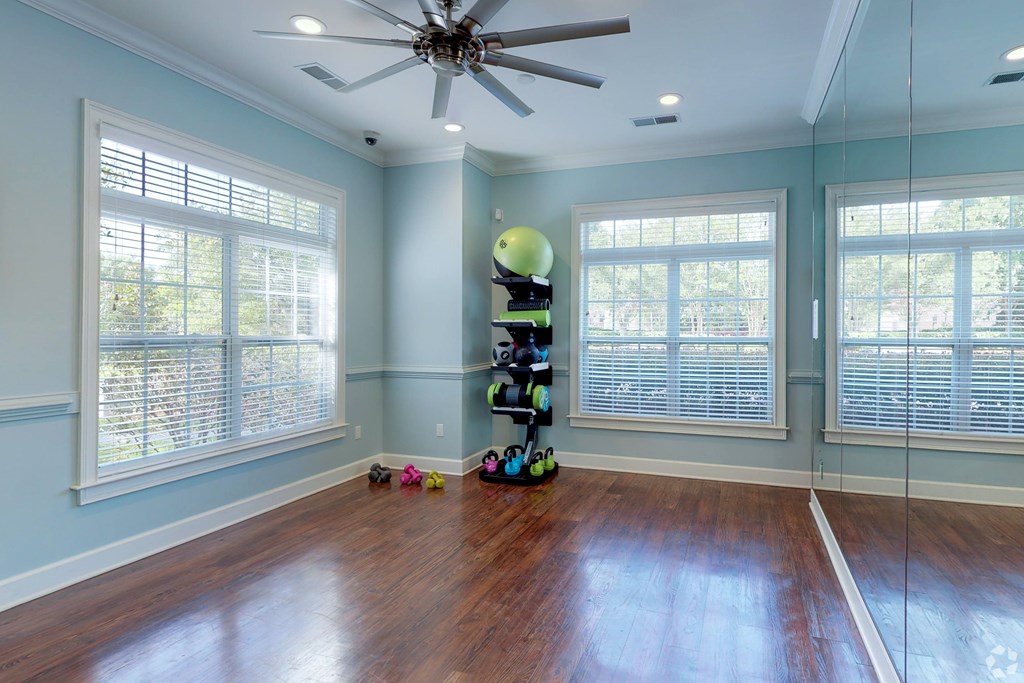 A room with a ceiling fan and a large window.