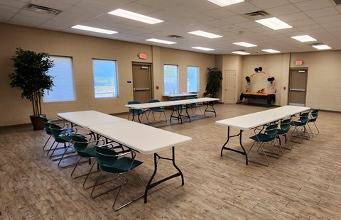 A room with tables and chairs and a tree.