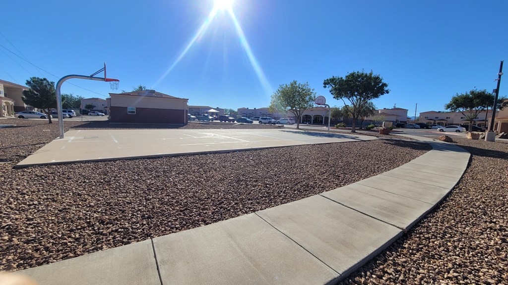 A basketball court with a sunny sky above.