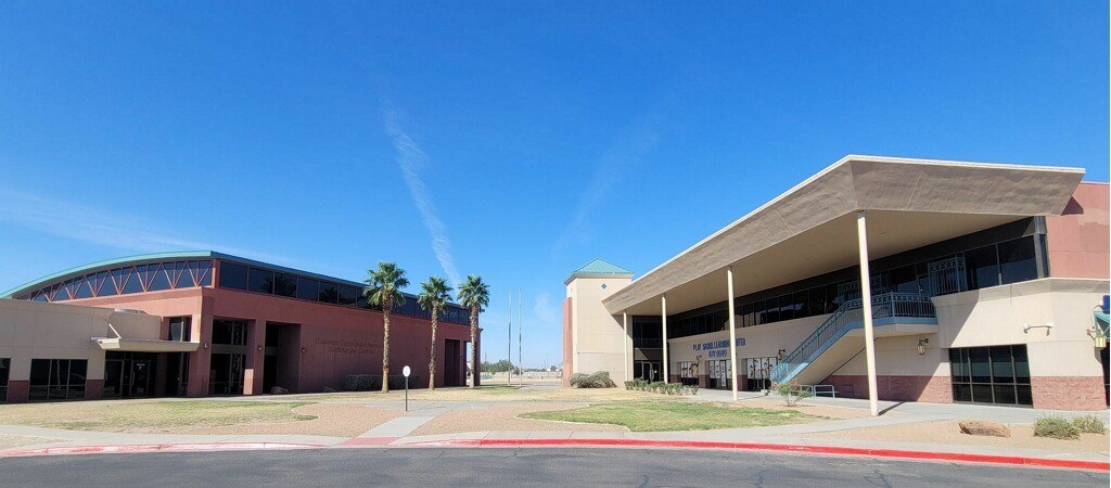 A modern building with a curved roof and a staircase leading to the entrance.