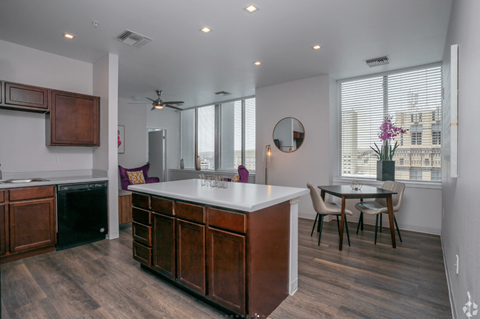 A kitchen with a white counter top and wooden cabinets.