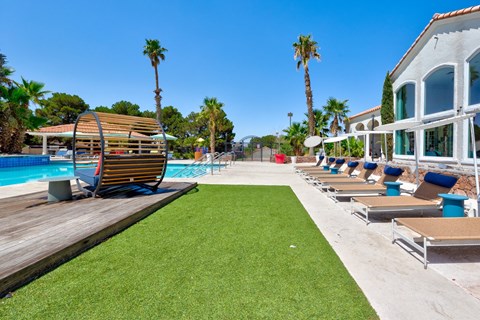 a row of lounge chairs next to a pool at a resort