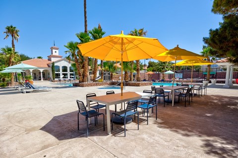 a group of tables with umbrellas and chairs in a pool