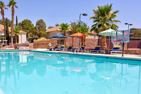 a swimming pool with chairs and umbrellas at a resort
