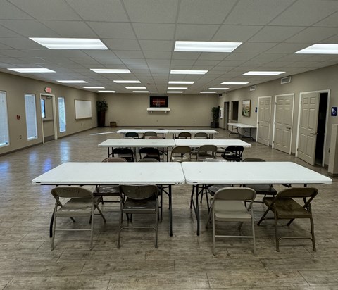 A large room with tables and chairs is empty.