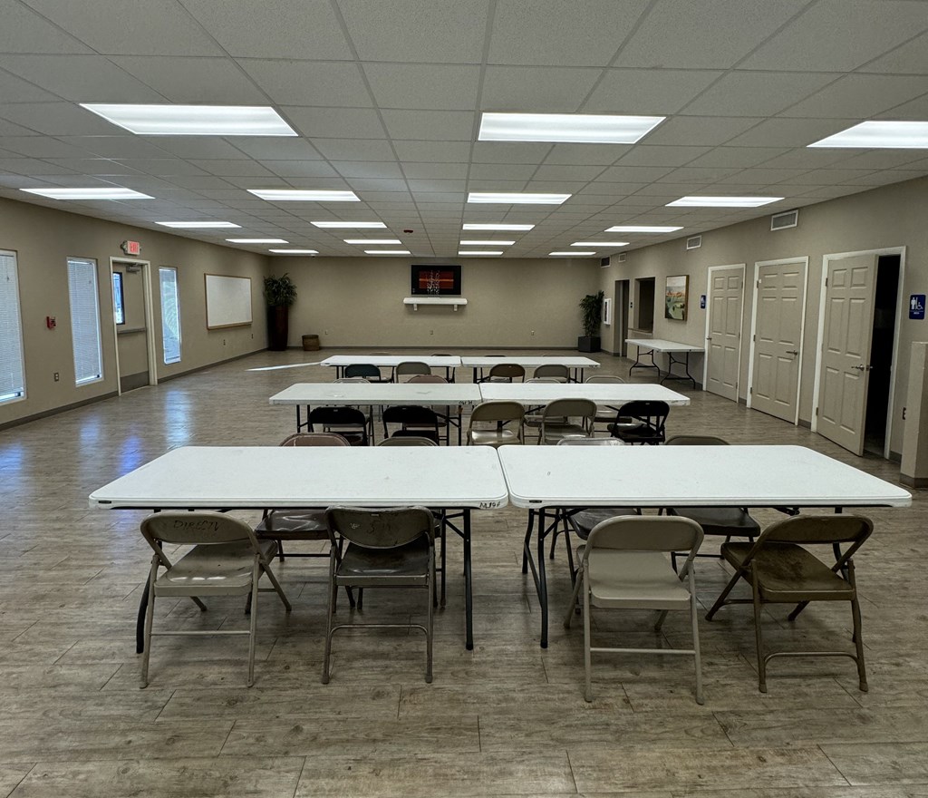 A large room with tables and chairs is empty.