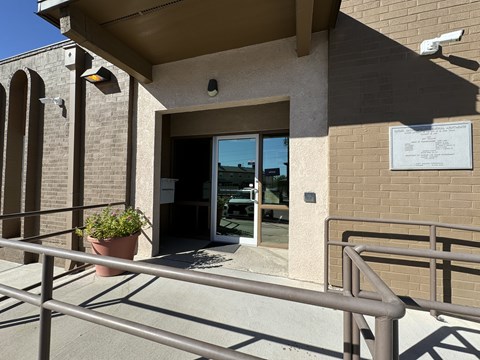 A building entrance with a sign and a potted plant.