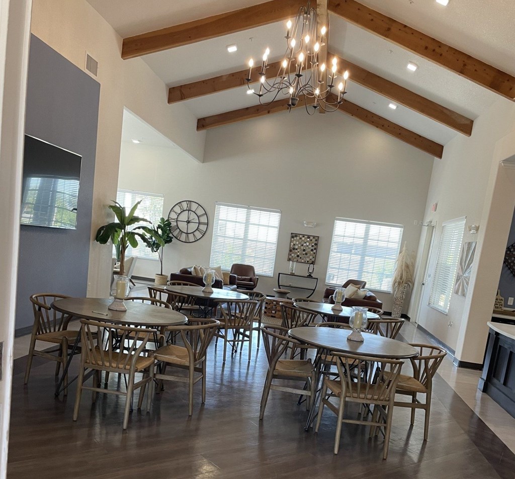 A dining room with a large table and chairs.