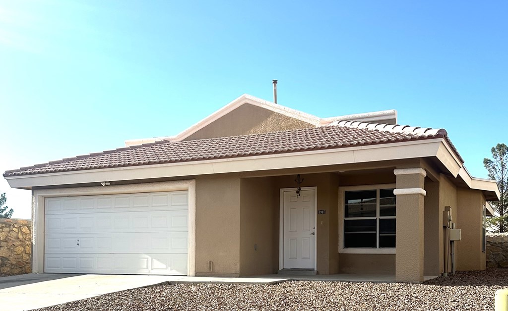 A house with a brown roof and a white garage door.