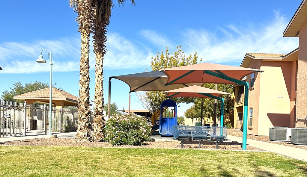A playground with a blue slide and a red canopy.