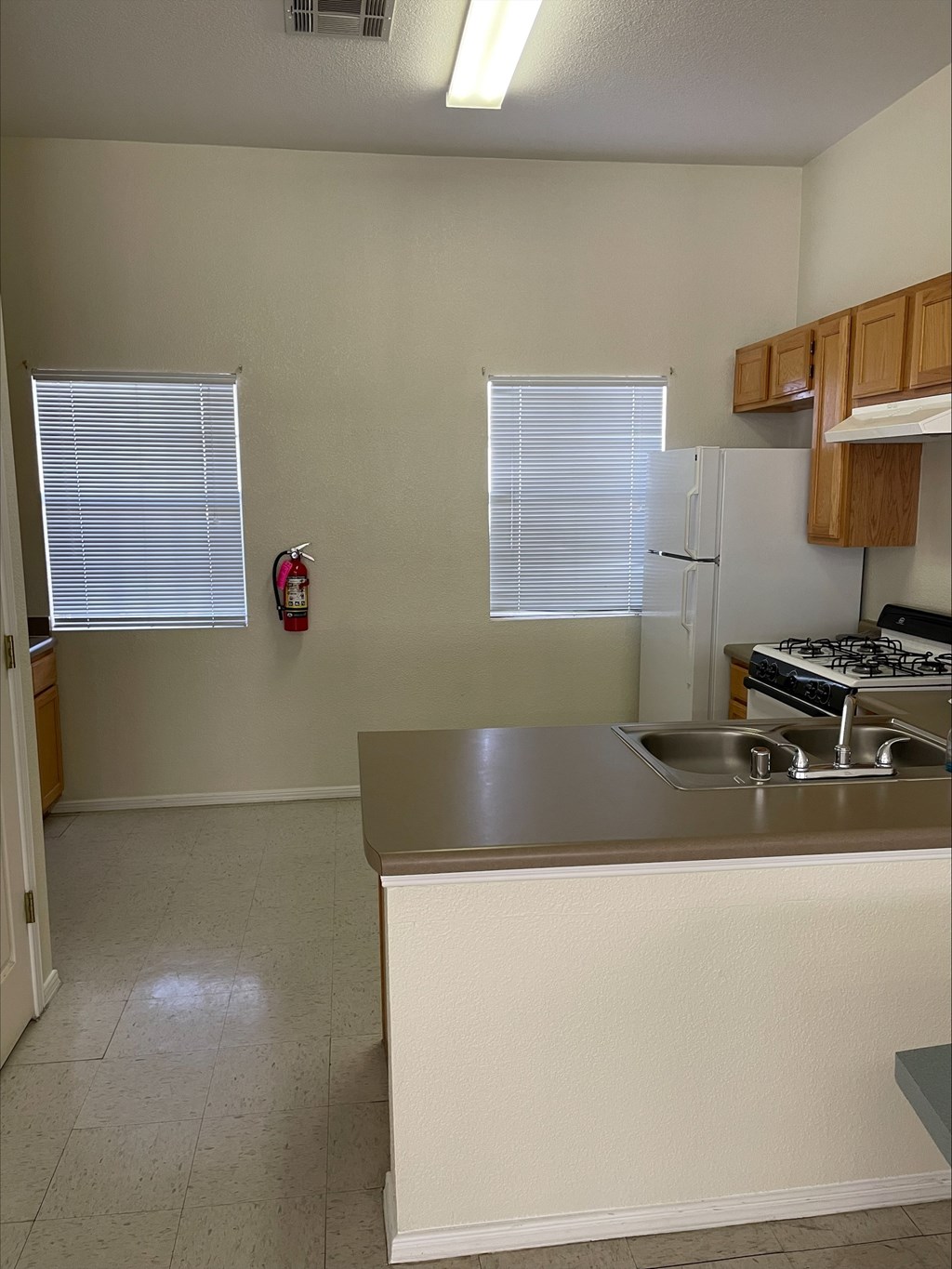 A kitchen with a white counter and a white fridge.