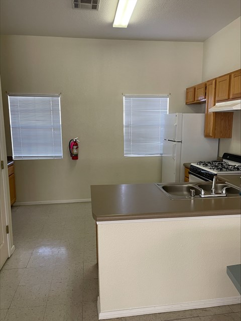 A kitchen with a white counter and a white fridge.