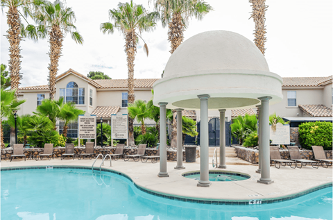 a swimming pool with chairs around it and palm trees