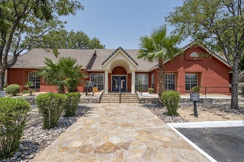 A red brick building with a stone pathway leading to the entrance.