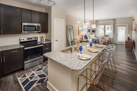A kitchen with a long island and a dining table set for two.