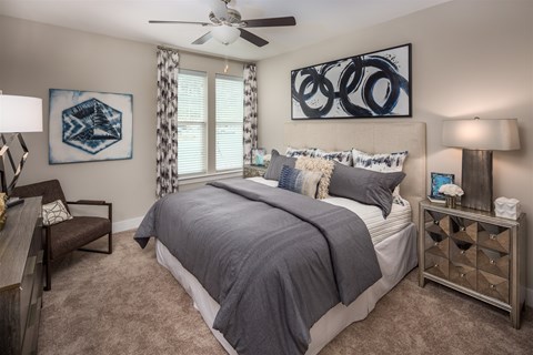 A bedroom with a large bed and a ceiling fan.
