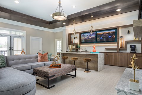 A modern living room with a grey sofa and a patterned coffee table.